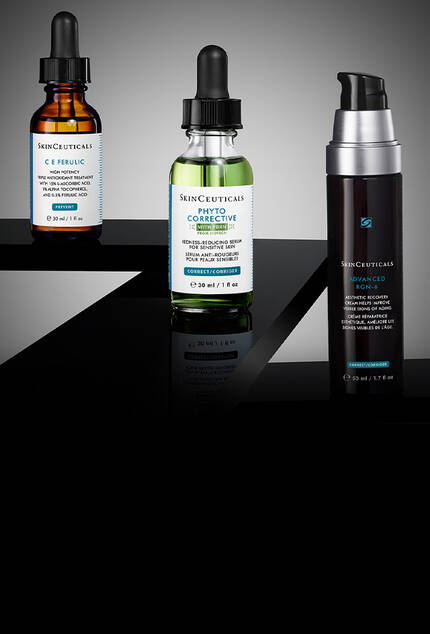 Vier Serum-Flaschchen von SkinCeuticals: das braune C E Ferulic, das durchsichtige P-TIOX, das blaue A.G.E. Interrupter Ultra und das lilafarbene HA Intensifier Multi-Glycan. Sie sind vor einem dunklen Hintergrund arrangiert, wodurch die einzelnen Flaschchen besonders ausdrucksstark hervorgehoben und in Szene gesetzt werden.