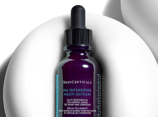 Ein Flaschchen mit Hautpflege-Serum von SkinCeuticals steht auf einem weißen, runden Hintergrund.