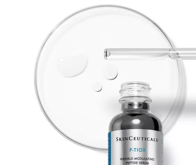 Ein Hautpflege-Serum von SkinCeuticals steht neben einer Petrischale mit Tropfen. Ideal fur die Faltenbehandlung.