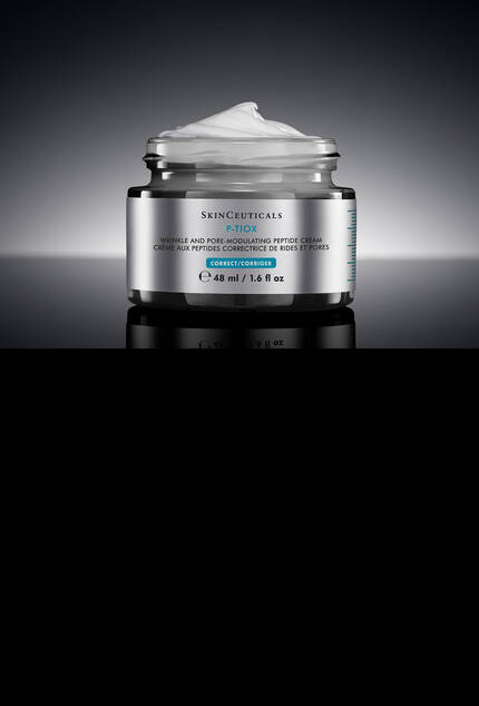 Un pot de SkinCeuticals P-TIOX Cream sur un fond sombre et epure, accompagne d’une goutte de serum transparente
