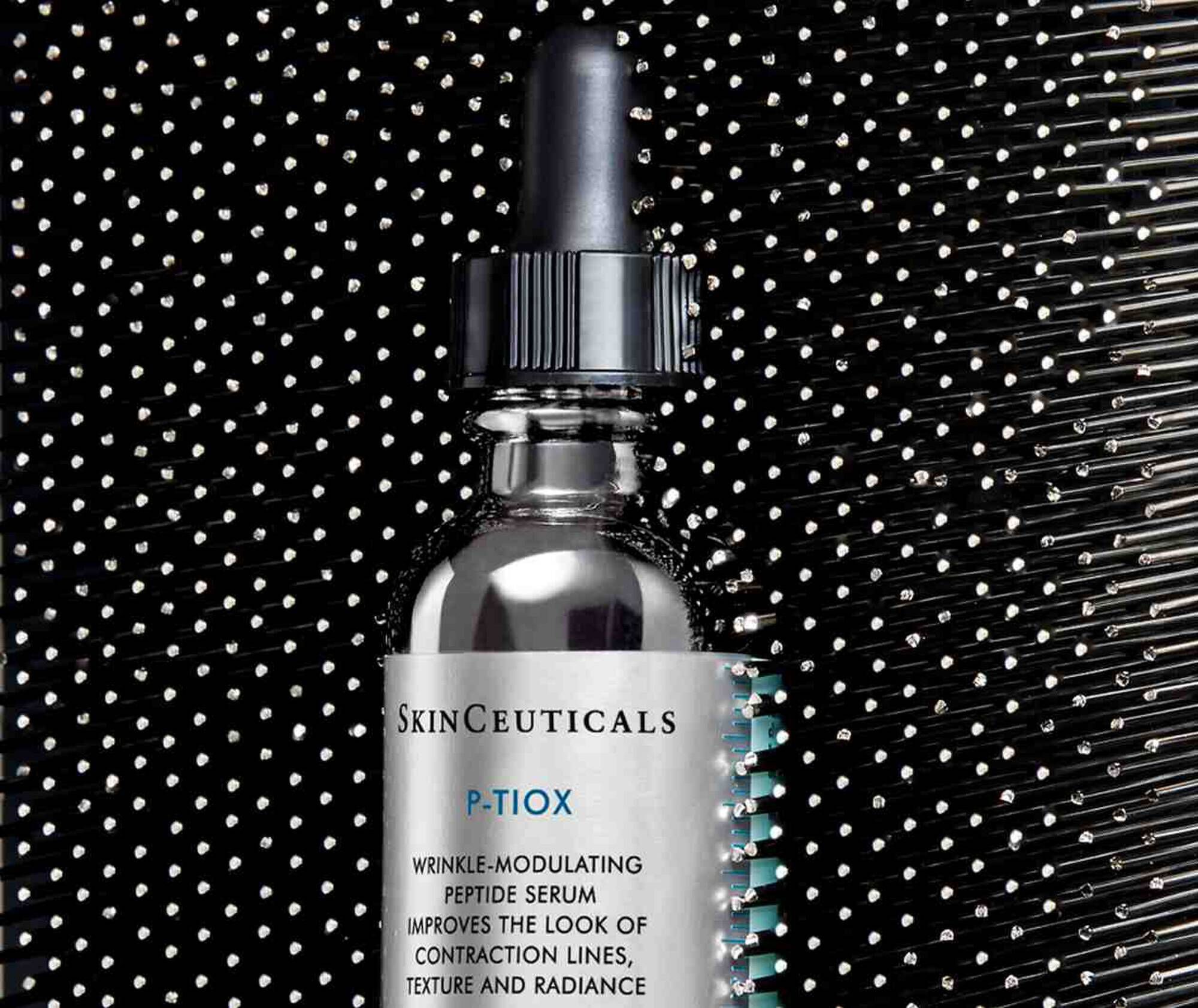 Ein Hautserum von SkinCeuticals in einer Flasche mit Pipette, auf einem stilvollen, schimmernden Hintergrund.