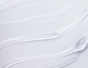 close-up of smooth, white cream or gel texture with flowing lines on a light background