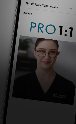 Eine Person mit Brille und schwarzem Oberteil lachelt in die Kamera, dargestellt auf einer SkinCeuticals Webseite.