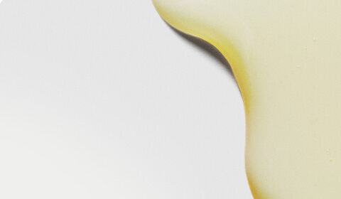 Abstract image featuring smooth, yellow oil droplets against a light background.