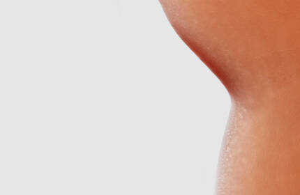 Abstract composition of fluid, skin-toned shapes on a white background, showcasing smooth textures and varying sizes.