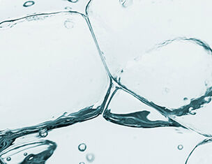 Des blocs de glace flottent dans de l'eau claire, creant des bulles et des reflets subtils.