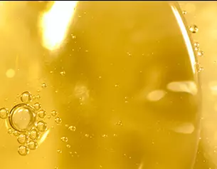 Gros plan sur des bulles d'air dans un liquide jaune, evoquant l'huile ou une boisson petillante.