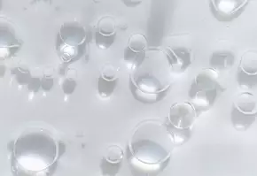 Des bulles d'air flottent dans un liquide transparent, creant un effet de lumiere et de reflexion.