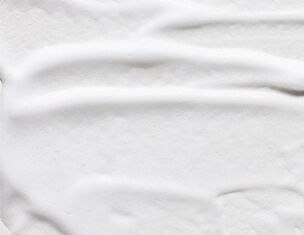 Creme blanche lisse etalee, texture onduleuse, evoquant la douceur et la legerete.