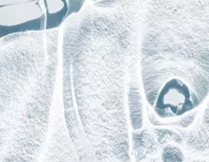 Abstract close-up of a translucent, icy surface with intricate patterns and textures, creating a cool, ethereal effect.