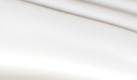 A close-up of a white surface featuring soft, wavy lines creating a subtle texture.