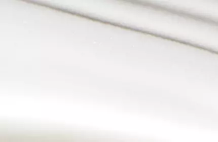 A close-up of a white surface featuring soft, wavy lines creating a subtle texture.