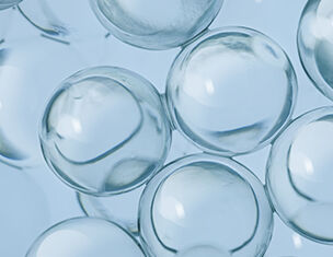 Des bulles transparentes prises de pres, flottant doucement sur un fond bleu clair.