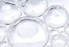 Gouttes d'eau transparentes formant des bulles sur un fond clair, evoquant la legerete et la fraicheur.