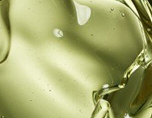 Gouttes d'huile d'olive verte se melangeant, creant une texture fluide et brillante.