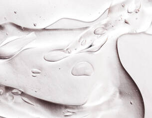 Texture fluide et brillante d'un gel transparent avec des gouttes d'eau sur une surface lisse et reflechissante.