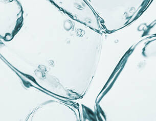 Nahaufnahme von Wasserblasen, die in transparenten, kuhleren Flussigkeiten aufsteigen.