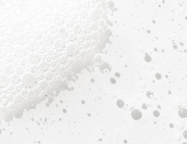 Close-up of white bubbles and foam against a light background, creating a soft, textured appearance.
