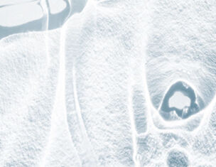 Abstract close-up of a textured surface, featuring subtle patterns and a central void, conveying a sense of depth and clarity.