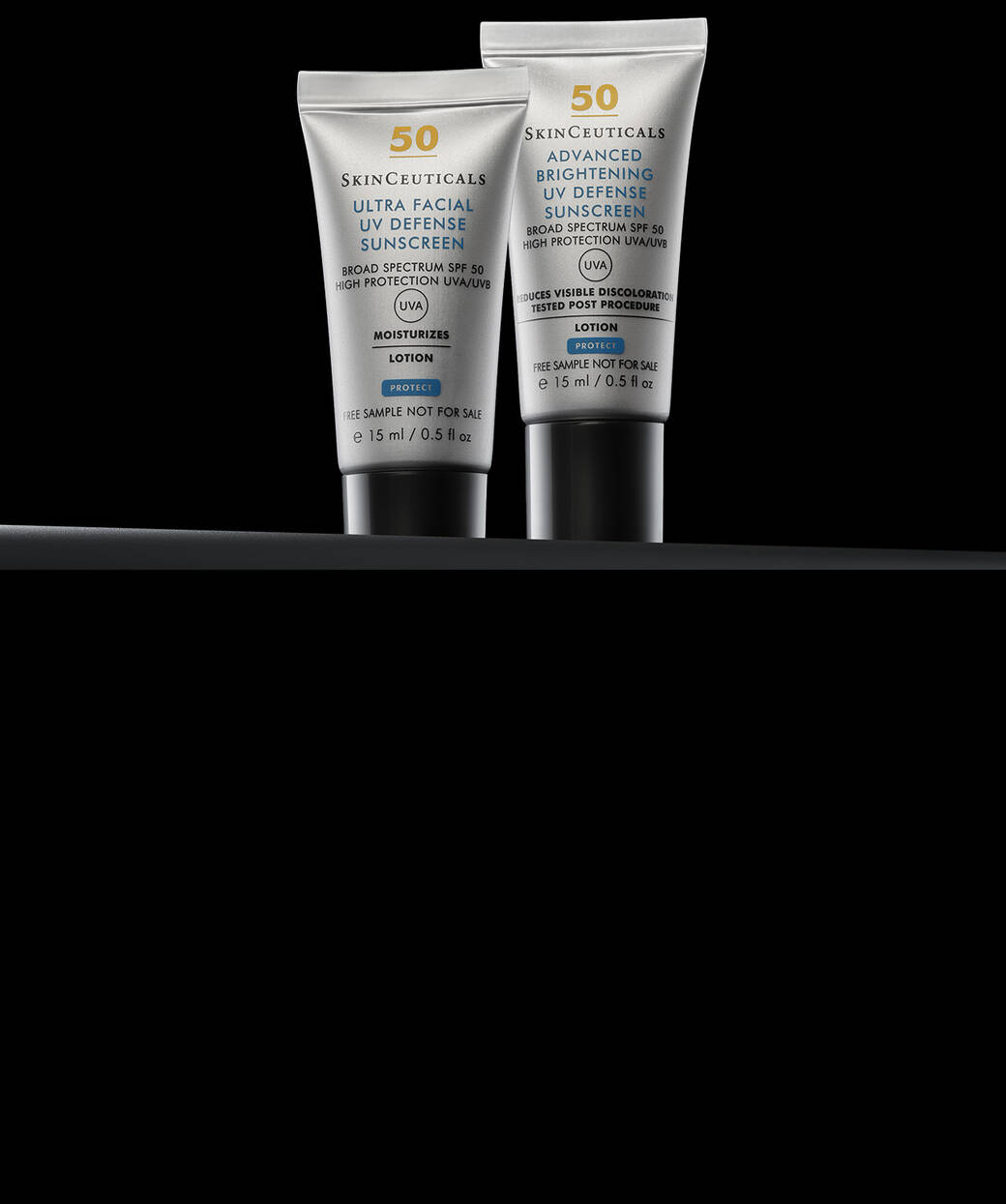 Gros plan sur deux flacons de creme solaire Skinceuticals, un Ultra Facial UV Defense et un Advanced Brightening UV Defense, sur fond noir.