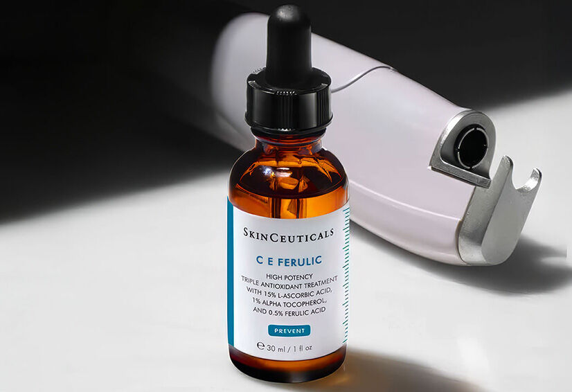 Ein flussiges Serum in einer lila Flasche von SkinCeuticals, umgeben von einer Spritze und einem Pipettendeckel.