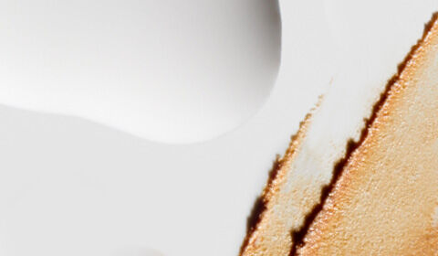 Abstract image featuring a smooth, light background with a textured section resembling dripped paint in warm tones.