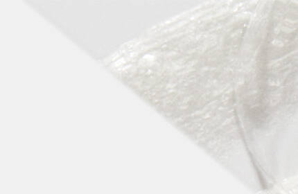 A close-up of a smooth, white substance with a soft texture, set against a light background.