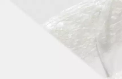A close-up of a smooth, white substance with a soft texture, set against a light background.