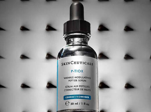 Flacon de serum visage SkinCeuticals sur fond noir avec une texture en relief.