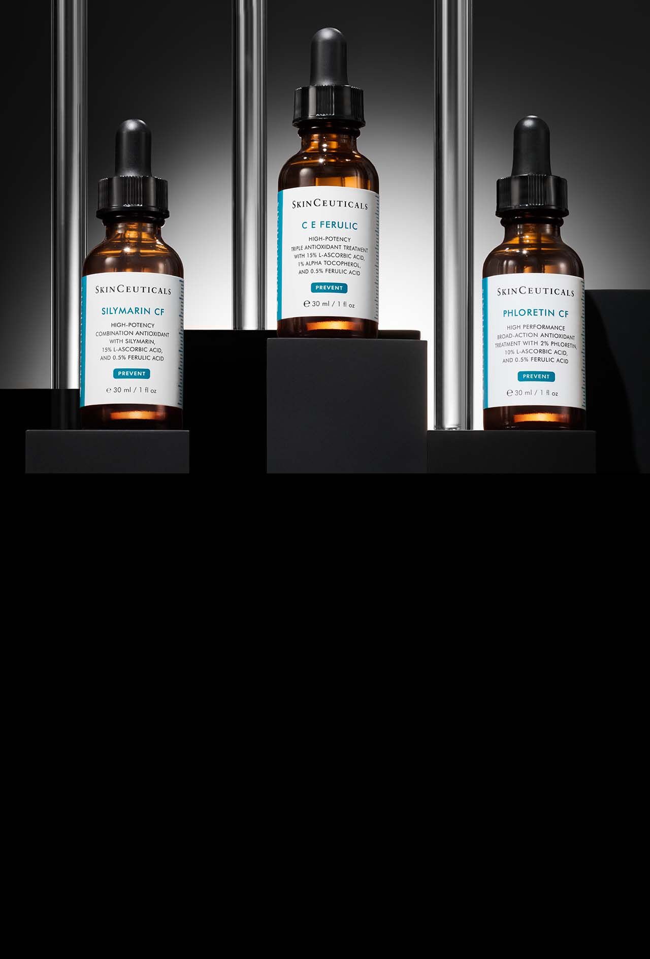 Trois flacons de serums antioxydants SkinCeuticals : Silymarin CF, C E Ferulic et Phloretin CF, disposes sur des socles noirs a plusieurs niveaux, sur un fond sombre rehausse de touches metalliques verticales.​