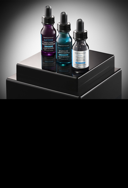Des flacons de serum et de soins de la peau disposes sur un fond clair.