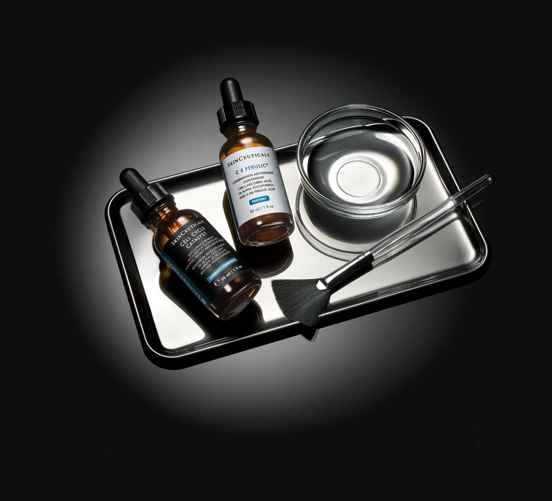 Quatre flacons de serums pour la peau sur une etagere, avec un fond noir elegant.