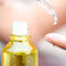 Bouteille d'huile avec un compte-gouttes, une goutte s'apprete a tomber sur un doigt.