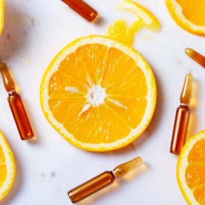 Une orange tranchee avec des segments et des ampoules en verre autour.