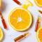 Une orange tranchee avec des segments et des ampoules en verre autour.